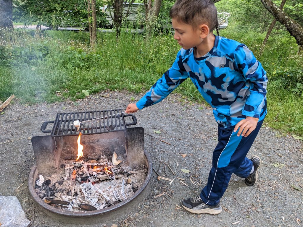 Liam cooks smores over the campfire.