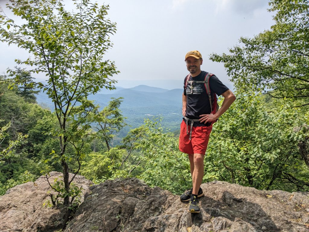 Picture of the Author standing at the precipice of Lewis Falls