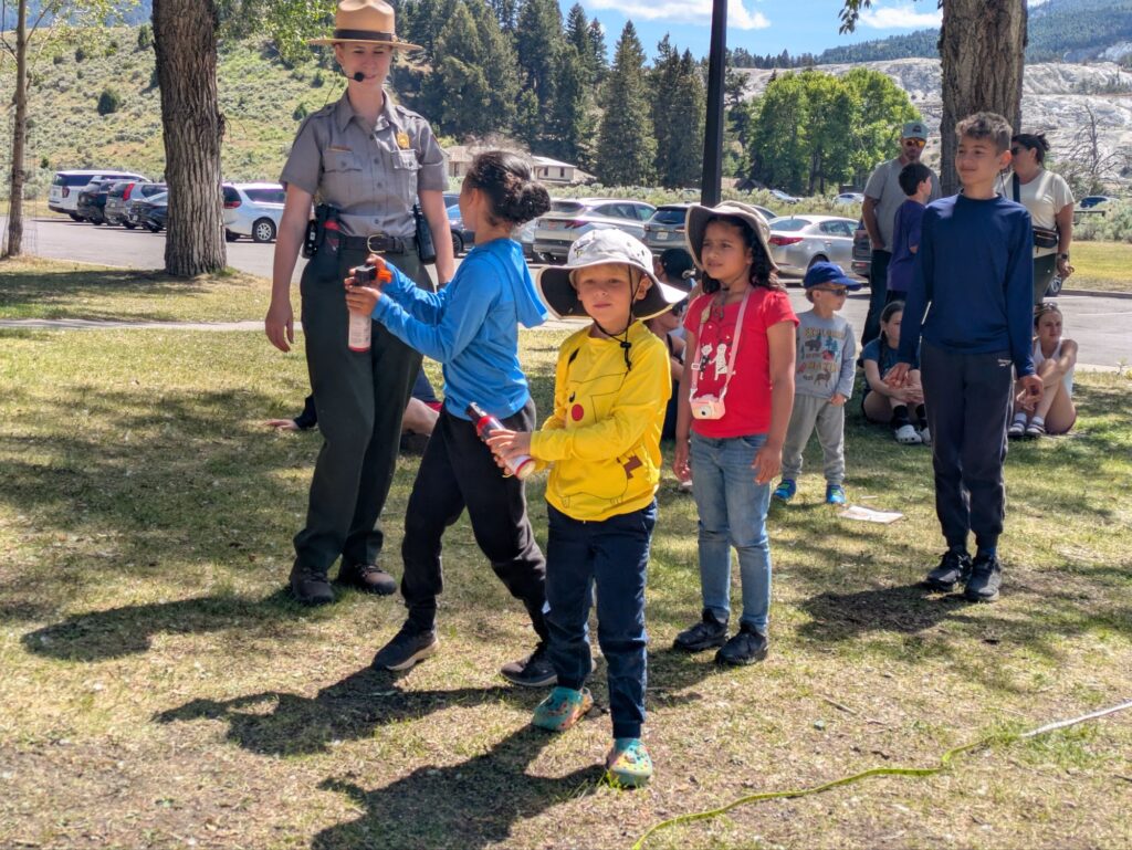 Boys getting a lesson on how to use Bear Spray