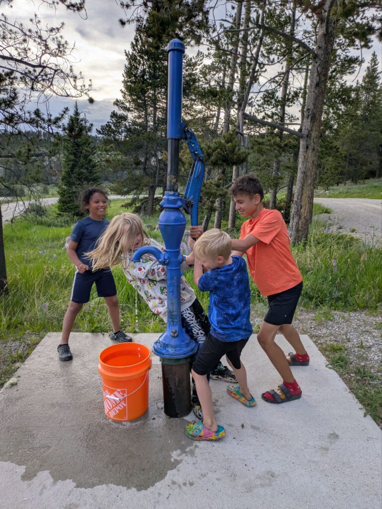 Working the water pump at camp to put out the campfire
